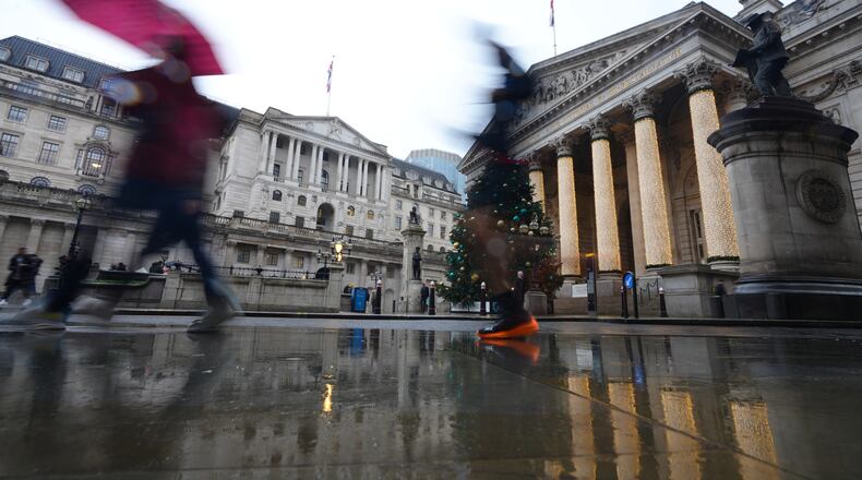 FILE - Pedestrians pass the Bank of England in London, on Dec. 18, 2025. (AP Photo/Kirsty Wigglesworth, File)