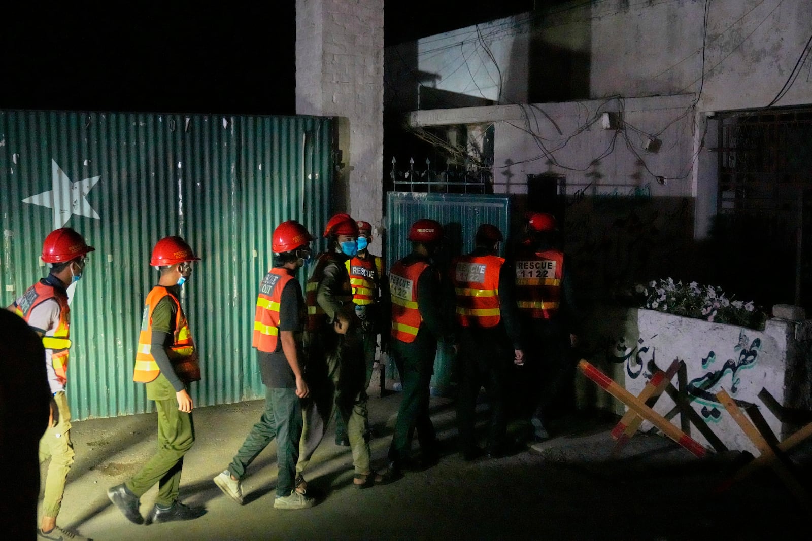 Rescue workers enter a building near the site of a suspected Indian missile attack, in Muridke, a town in Pakistan's Punjab province, Wednesday, May 7, 2025. (AP Photo/K.M. Chaudary)