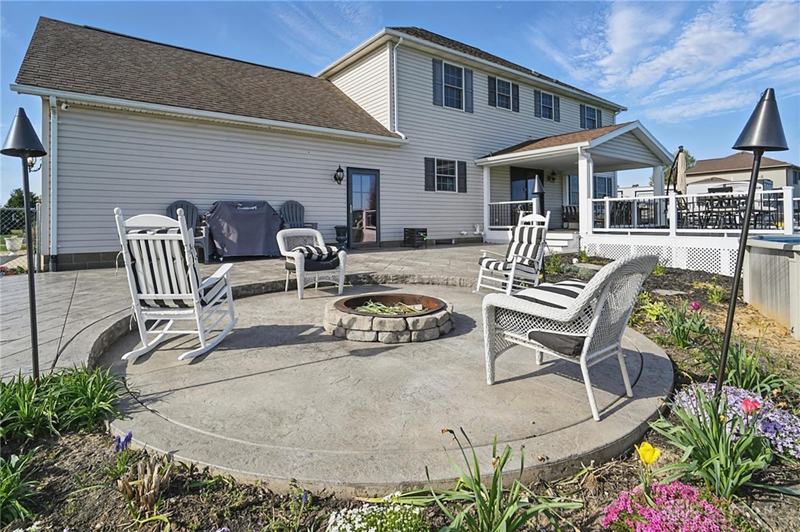 The back yard features a partially covered composite deck with built in above ground pool and a stamped concrete patio with fire pit.