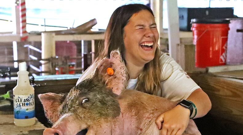 Tesa Berber, 14, laughes as she struggles to keep her pig from jumping out of the washing pen Saturday, July 23, 2022, at the Clark County Fair. The image was one of six Springfield News-Sun photographer Bill Lackey submitted to the Ohio Society of Professional Journalists to earn Ohio Photographer of the Year, an award announced Monday. BILL LACKEY/STAFF