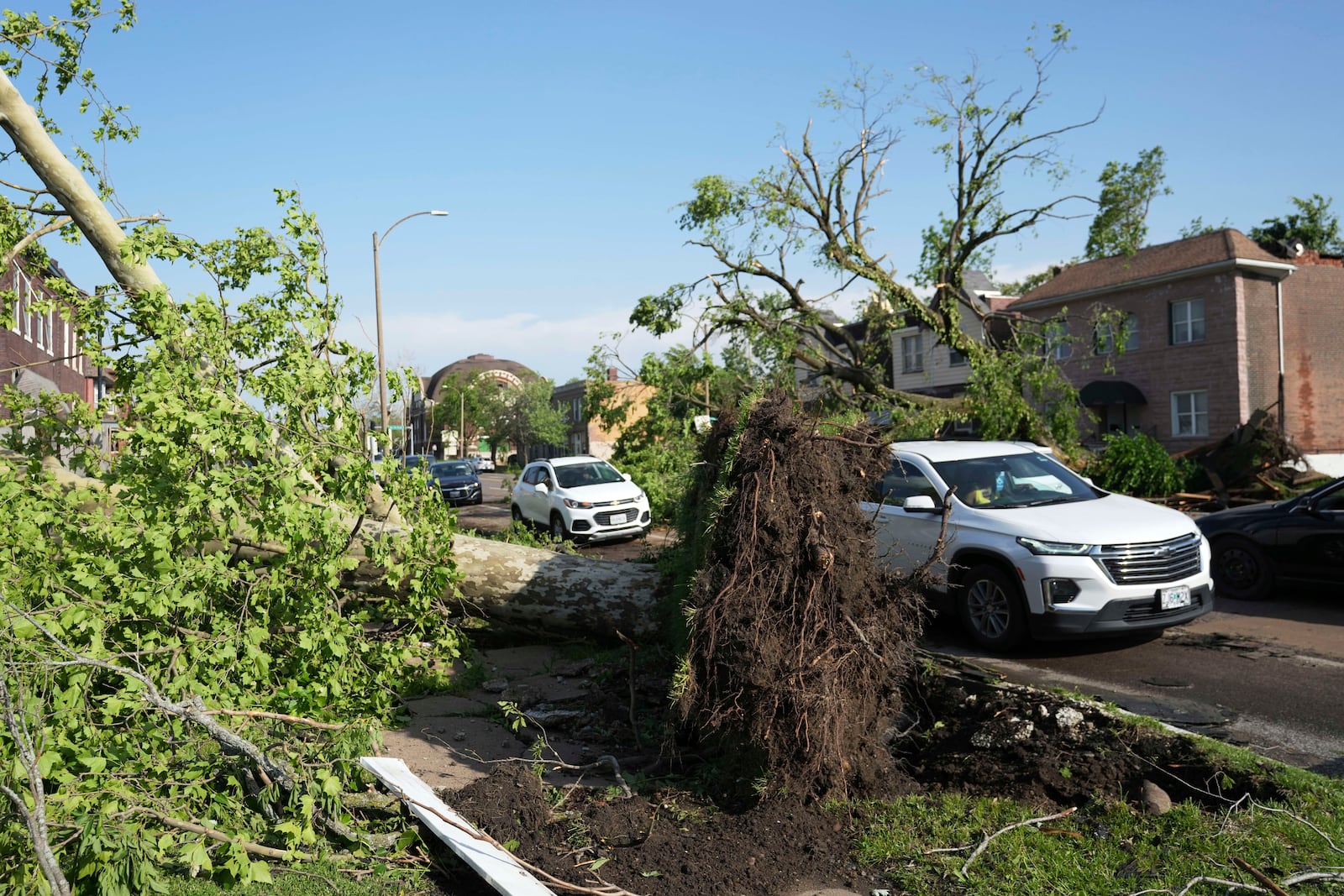 Drivers navigate around debris in the roadway after a severe storm moved through Friday, May 16, 2025, in St. Louis. (AP Photo/Jeff Roberson)