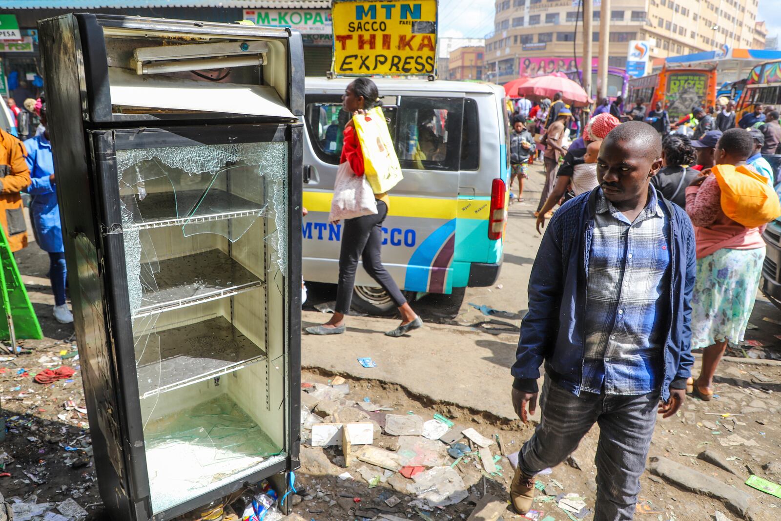 Business owners assess the damage to their vandalized merchandise and shop, following the one-year anniversary of a deadly anti-tax demonstration in Nairobi, Kenya, Thursday, June 26, 2025. (AP Photo/Patrick Ngugi)