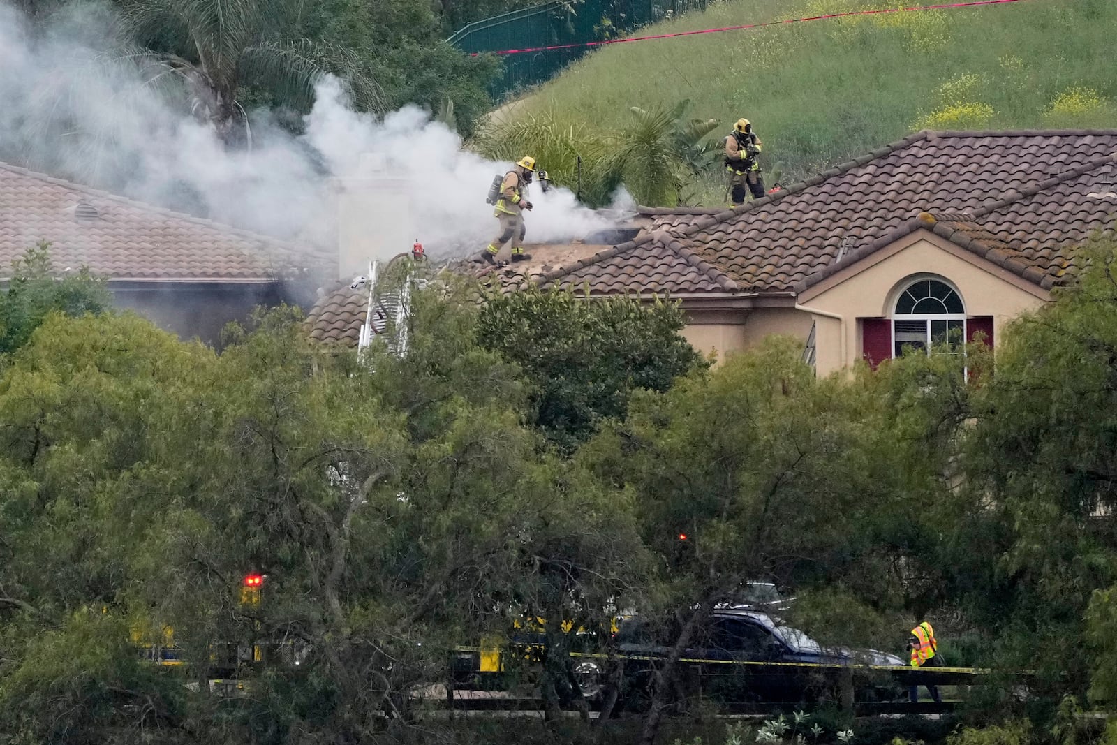 Firefighters work at the site of a plane crash in the Wood Ranch section of Simi Valley, Calif., on Saturday, May 3, 2025. (AP Photo/Mark J. Terrill)