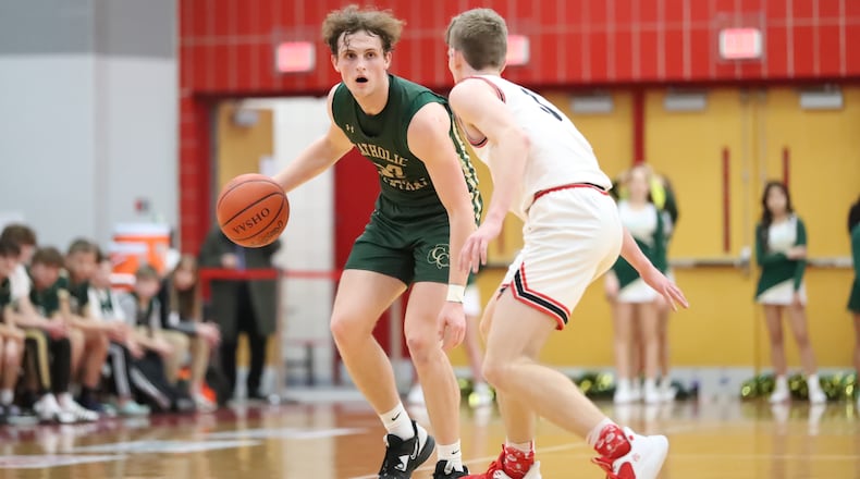 Catholic Central senior Cole Ray is guarded by Cedarville's Drew Koning during their Division IV district semifinal game on Saturday at Troy High School. CONTRIBUTED PHOTO BY MICHAEL COOPER