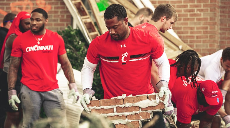 Cincinnati defensive coordinator and Wayne High School alumnus Marcus Freeman was part of the cleanup effort in Trotwood on Friday.