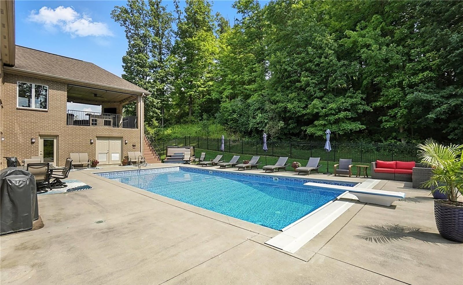 The inground saltwater pool has a diving board and concrete patio. There is a dedicated room at the basement level for pool storage.