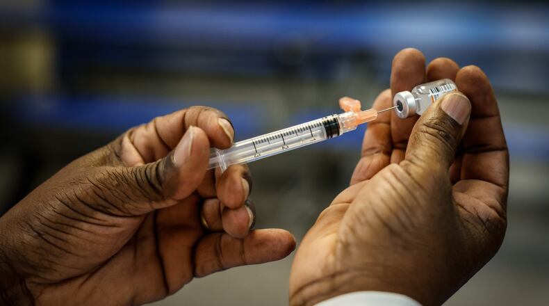 Anthony Watson R.N. fills a syringe with COVID-19 vaccine at a clinic held at Horizon Science Academy Friday March 11, 2022. JIM NOELKER/STAFF
