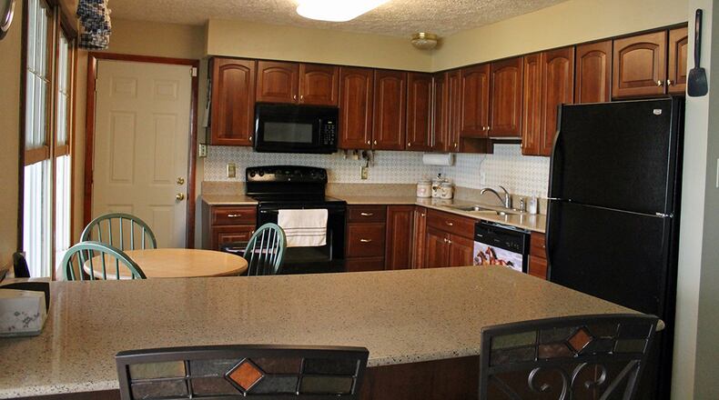 Features of the kitchen include a breakfast bar and plenty of cherry cabinetry.