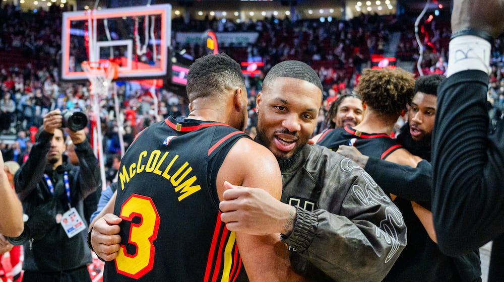 Portland Trail Blazers guard Damian Lillard, right, and Atlanta Hawks guard CJ McCollum, left, embrace after an NBA basketball game on Thursday, Jan. 15, 2026, in Portland, Ore. (AP Photo/Molly J. Smith)