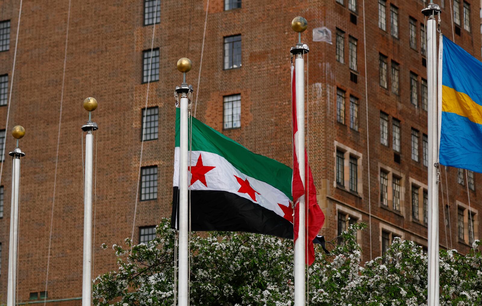 The Syrian Flag is raised during a ceremony where it was added to the 100 flags flying in line at United Nations Headquarters on Friday, April 25, 2025. (AP Photo/Kena Betancur)