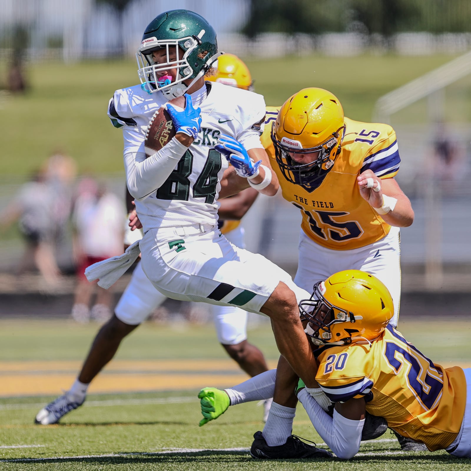 A group of Springfield High School football players tackle a Louisville Trinity receiver during their scrimmage on Aug. 9 in Springfield. MICHAEL COOPER / STAFF