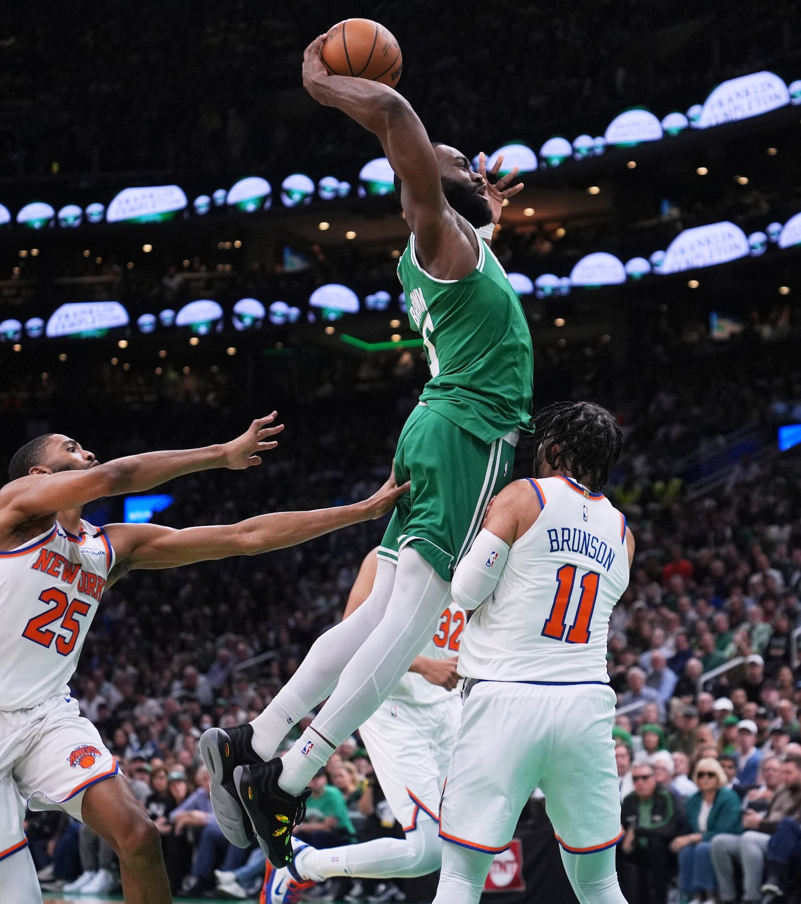 Boston Celtics guard Jaylen Brown, center, drives to the basket against New York Knicks guard Jalen Brunson (11) during the first half of Game 2 of an NBA basketball second-round playoff series, Wednesday, May 7, 2025, in Boston. (AP Photo/Charles Krupa)