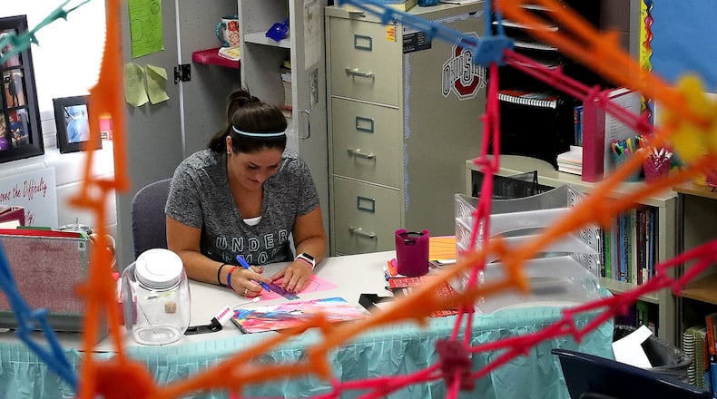 Kristen Fitzsimmons, a sixth grade math teacher at Simon Kenton Elementary, gets her classroom ready Friday for class to soon start. BILL LACKEY/STAFF
