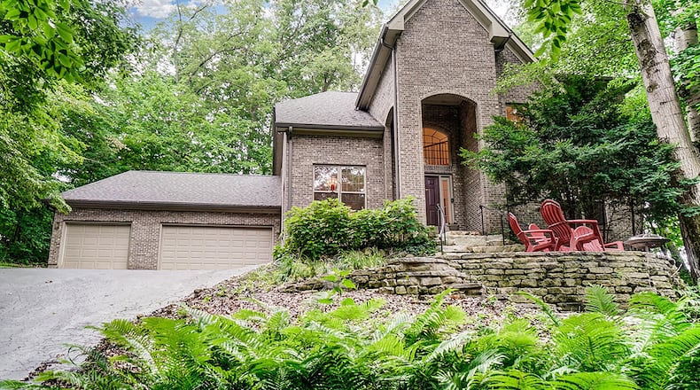 The custom, brick 2-story features a cobbled brick pathway to the front entry. The 3-bedroom home on a wooded, 1.71-acre lot offers about 3,210 sq. ft. of living space and a heated, 3-car garage. CONTRIBUTED PHOTO