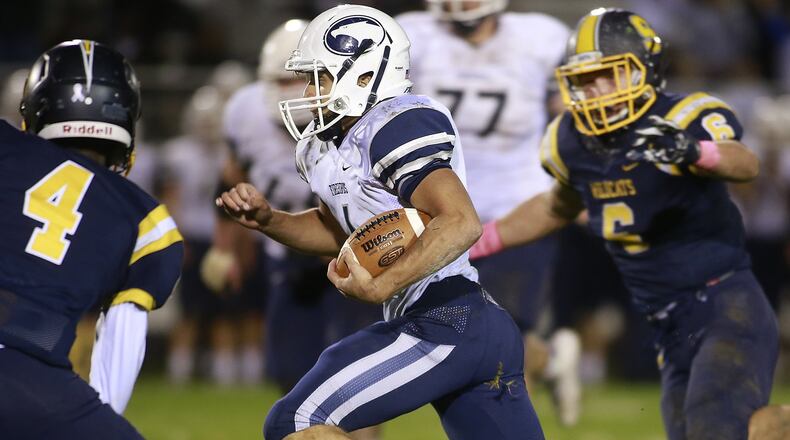 Fairmont’s Kennon Burroughs runs between Springfield’s Jaherinn Echols, left, and Cameron Hoelscher as he carries the ball. Bill Lackey/Staff