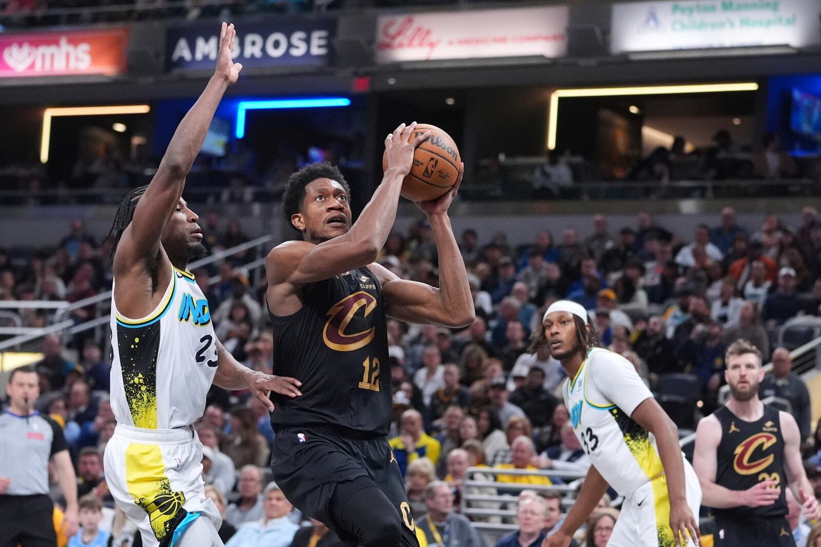 Cleveland Cavaliers forward De'Andre Hunter (12) shoots in front of Indiana Pacers forward Aaron Nesmith (23) during the first half of an NBA basketball game in Indianapolis, Thursday, April 10, 2025. (AP Photo/Michael Conroy)