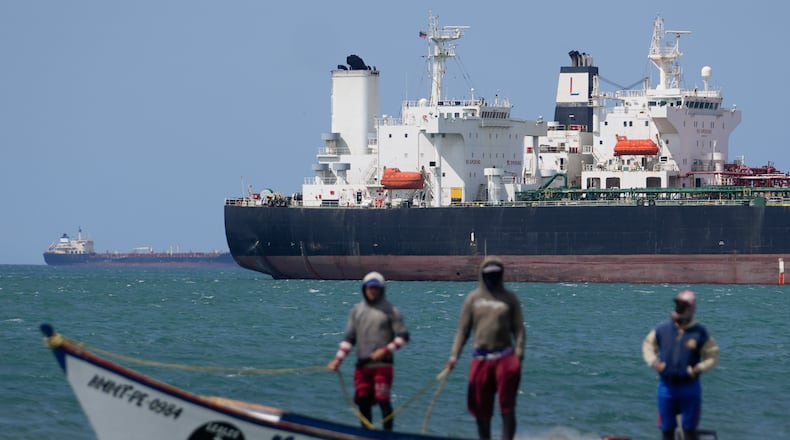 FILE - Fishermen pass an oil tanker in the Gulf of Venezuela off the shore of Punta Cardon, Venezuela, Jan. 14, 2026. (AP Photo/Matias Delacroix, FIle)