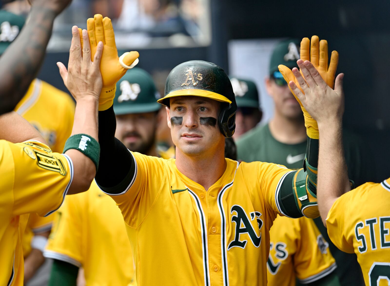 Athletics' Brent Rooker is greeted in the dugout after hitting a solo home run in the first inning of a baseball game against the Tampa Bay Rays, Wednesday, July 2, 2025, in Tampa, Fla. (AP Photo/Jason Behnken)