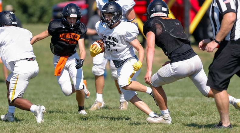 Cutline: Shawnee High School senior Connar Earles runs the ball between two Minster defenders during their scrimmage on Saturday, Aug. 10 in Springfield. Michael Cooper/CONTRIBUTED