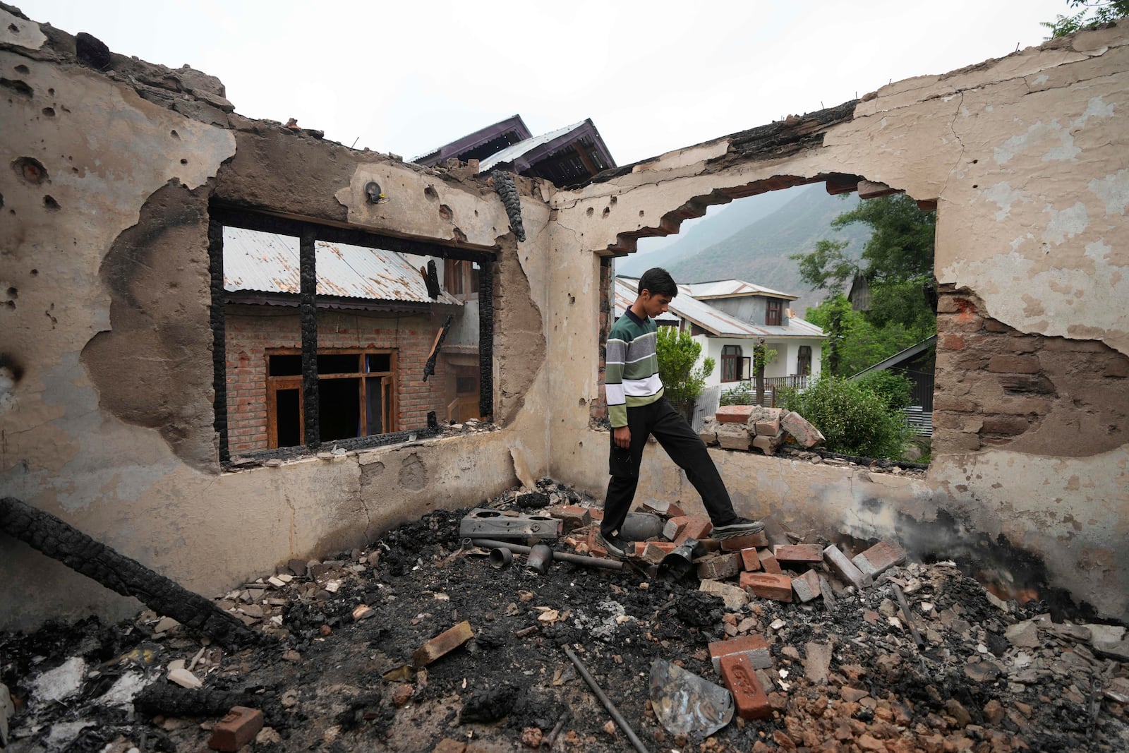 A Kashmiri village boy walks inside a house damaged by Pakistani artillery shelling, at Salamabad village in Uri ,north of Srinagar, Indian controlled Kashmir, Thursday, May 8, 2025. (AP Photo/Mukhtar Khan)