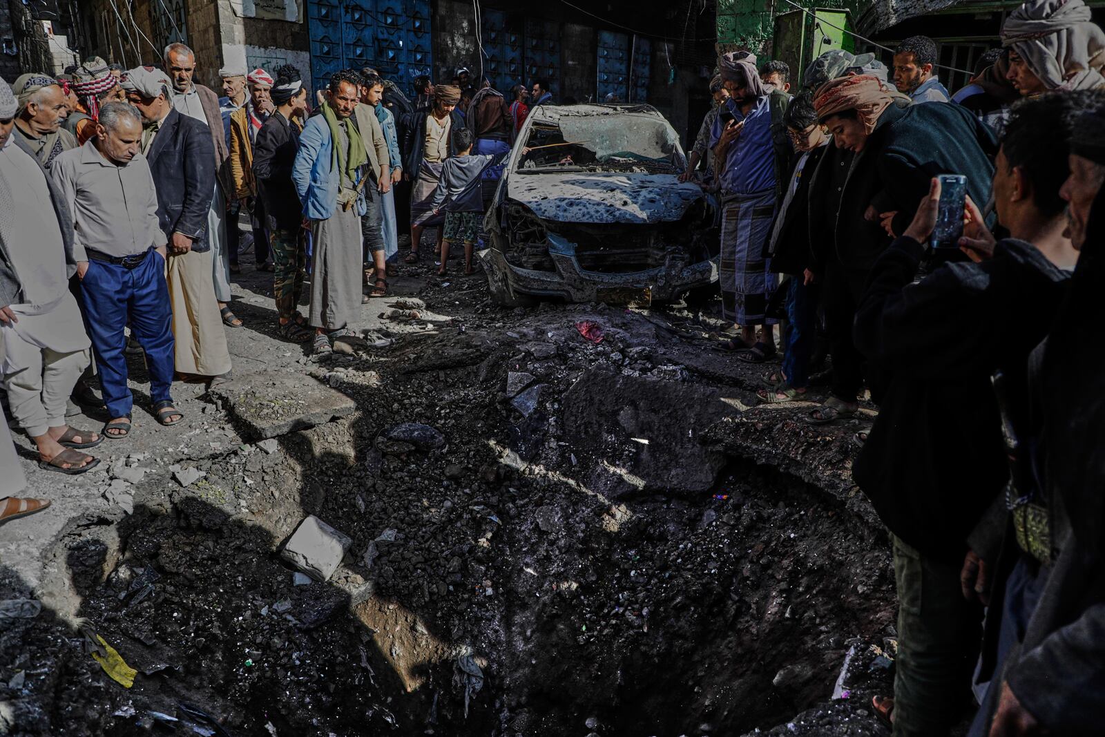 Yemenis watch a hole at Farwah popular market, which Houthis said was struck by U.S. airstrikes, in Sanaa, Yemen, Monday, April 21, 2025. (AP Photo)