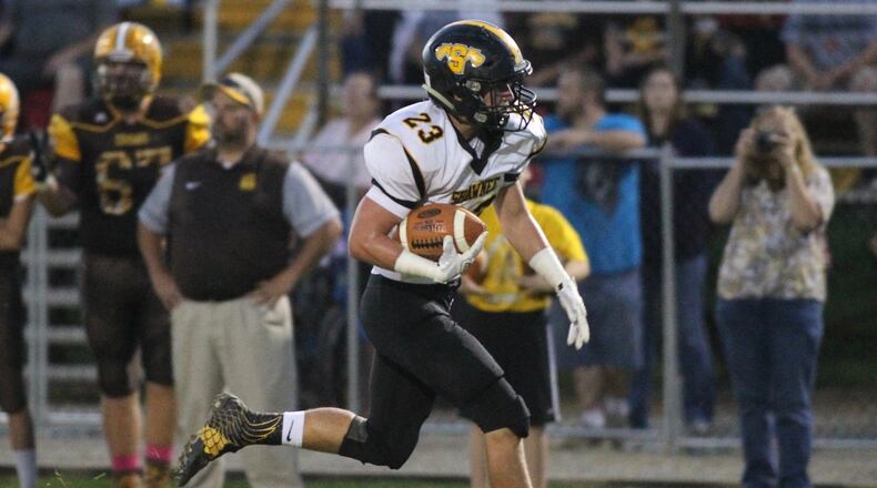 Tecumseh’s Brody Martin is brought down by Kenton Ridge’s Nasir Carter as he carries the ball. Bill Lackey/Staff