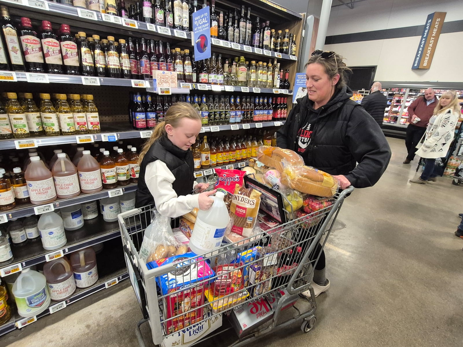 Jessica Turner and her daughter, Alyssa, navigate the heavy crowds Thursday at the Springboro Kroger on West Central Avenue. Michael Kurtz / Staff