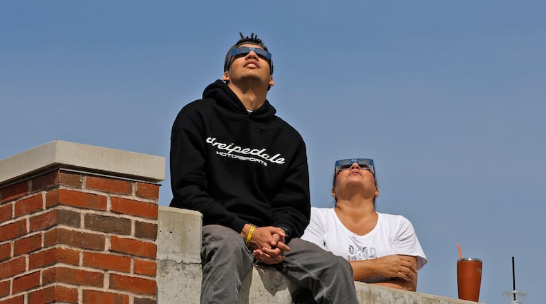 People watch the solar eclipse Monday, April 8, 2024 from the top of the Springfield parking garage. BILL LACKEY/STAFF