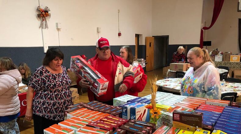 Victory Faith Center Pastor Pauline Hamblin helps a family select items to help this holiday seasons during a giveaway event that saw hundreds of toys and food items passed to the city's needy. Phioto by Brett Turner