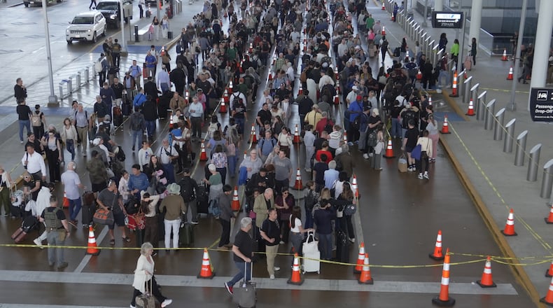 Travelers line up at a TSA checkpoint at George Bush Intercontinental Airport in Houston, Thursday, March 26, 2026. (AP Photo/Lekan Oyekanmi)