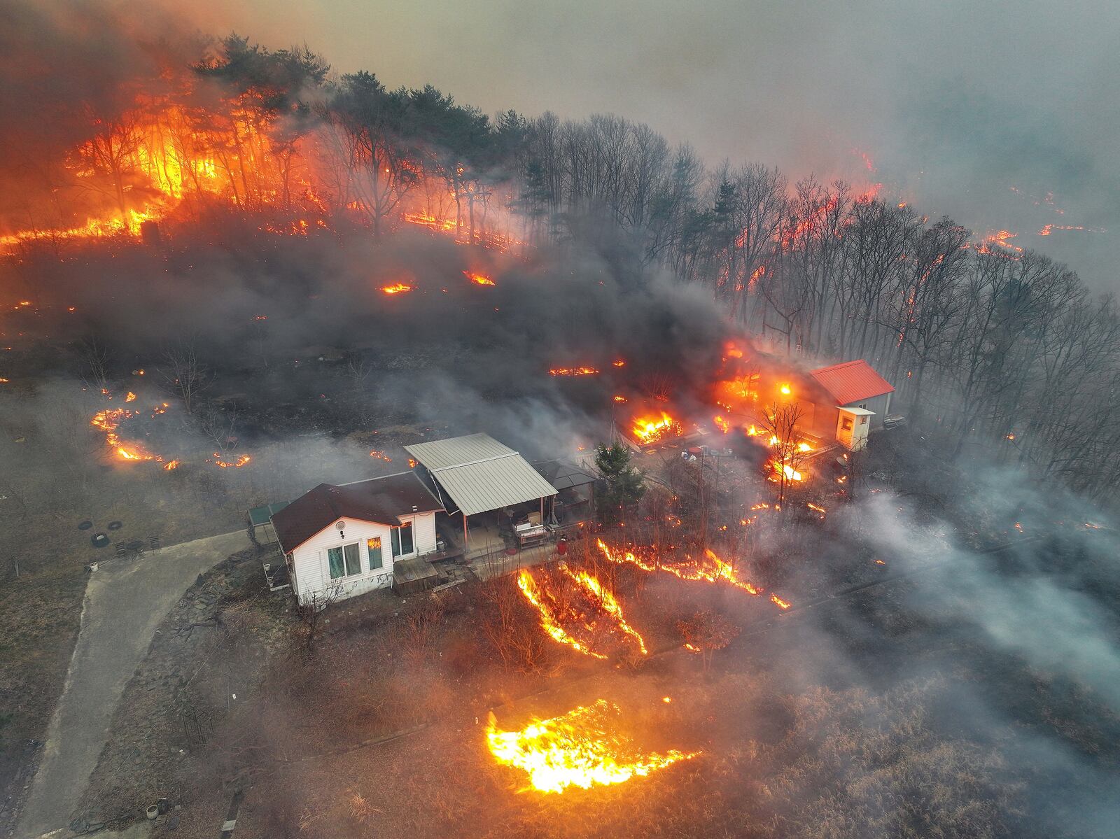 Houses burn in a village after being engulfed by a wildfire fueled by strong winds in Uiseong, South Korea, Monday, March 24, 2025. (Yoon Gwan-shick/Yonhap via AP)