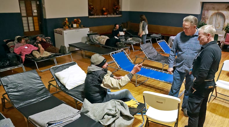 Volunteers talk with a man who came in to get warm the evening of Dec. 3, 2024 at the warming shelter in the Victory Faith Center gymnasium. The shelter was organized by Kenneth "Barron" Seelig with help from community volunteers as temperatures dropped below freezing outside. BILL LACKEY / STAFF
