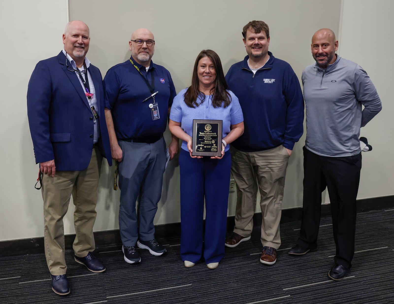 Tonya Collinsworth, eighth grade science teacher at Shawnee Middle School, takes a photo with her faculty while holding the Excellence in Teaching award she received at a luncheon at the Hollenbeck Bayley Center on Monday, March 23, 2026, in Springfield. JOSEPH COOKE/STAFF