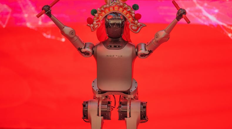 A humanoid robot wearing a traditional headdress is displayed during a media preview of a robotic temple fair ahead of Lunar New Year in Beijing, China, Friday, Feb. 13, 2026. (AP Photo/Vincent Thian)