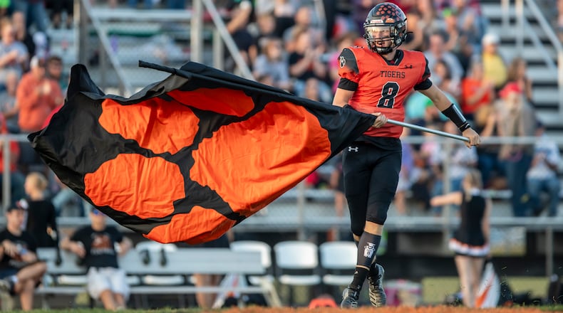 West Liberty-Salem High School senior Miles Hostetler waves a Tigers flag before their game against Northeastern earlier this season at Tiger Stadium in West Liberty. Michael Cooper/CONTRIBUTED