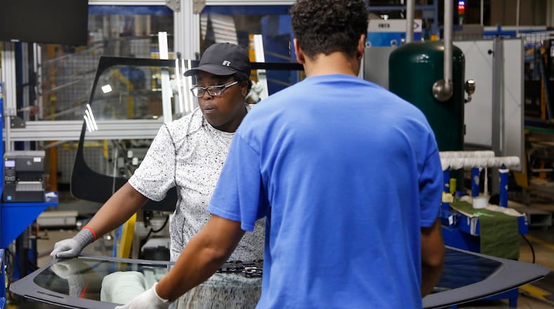Workers at Fuyao Glass America finish an automobile windshield in the Moraine plant. Fuyao currently employs 2,300 workers and expects to need 700 more within three years. TY GREENLEES / STAFF