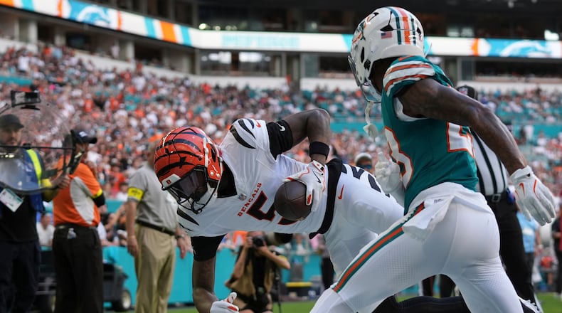 Cincinnati Bengals wide receiver Tee Higgins (5) scores a touchdown while being defended by Miami Dolphins cornerback Jack Jones (23) during the first half of an NFL football game, Sunday, Dec. 21, 2025, in Miami Gardens, Fla. (AP Photo/Lynne Sladky)
