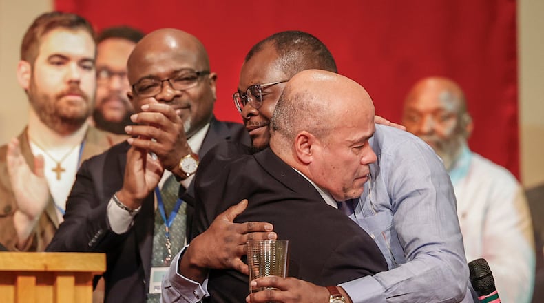 Pastor Jose Salas, front, hugs Viles Dorsainvil, co-founder and executive director of the Haitian Community Help & Support Center, during Here We Stand: Faith Leaders for Immigration Justice & Family Unity at St. John Missionary Baptist Church on Monday, Feb. 2, 2026, in Springfield. Pastors, faith leaders and community members gathered to pray and call for the extension of Temporary Protected Status which is scheduled to expire on Tuesday, Feb. 3, 2026. JOSEPH COOKE/STAFF