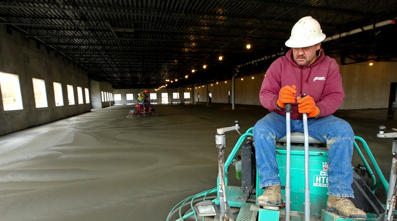John Flaig works to smooth the concrete floor inside Western States Machine Co.'s new plant being constructed in Fairfield Friday, April 12, 2013. NICK DAGGY / STAFF