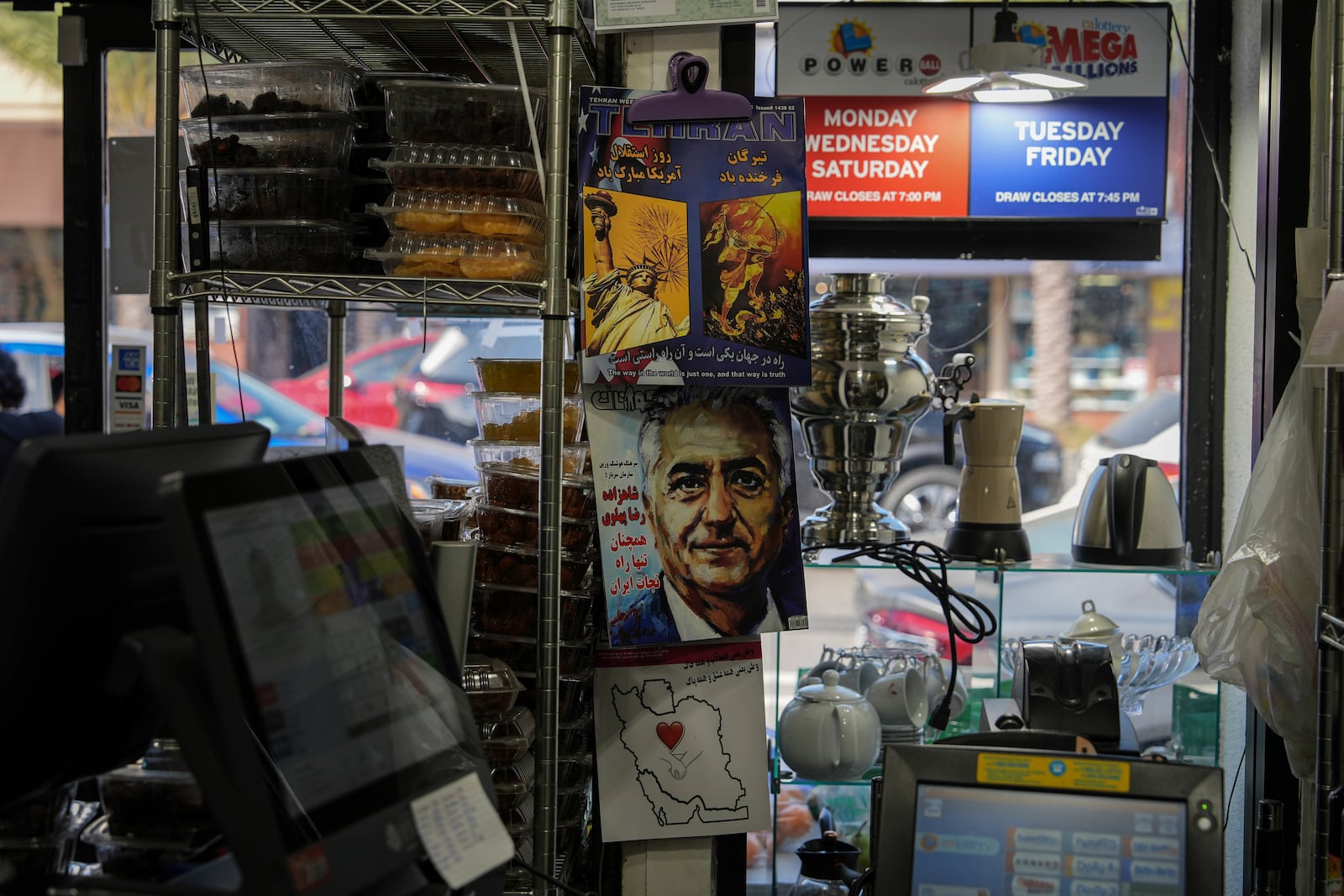 Persian-language magazines are displayed near the register of a grocery store in the "Tehrangeles" neighborhood of Los Angeles Tuesday, June 24, 2025. (AP Photo/Jae C. Hong)