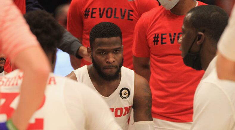 Dayton's Anthony Grant talks to players, including Jalen Crutcher, center, in a huddle during a game against George Mason in the final minutes on Saturday, Jan. 2, 2020, at UD Arena. David Jablonski/Staff