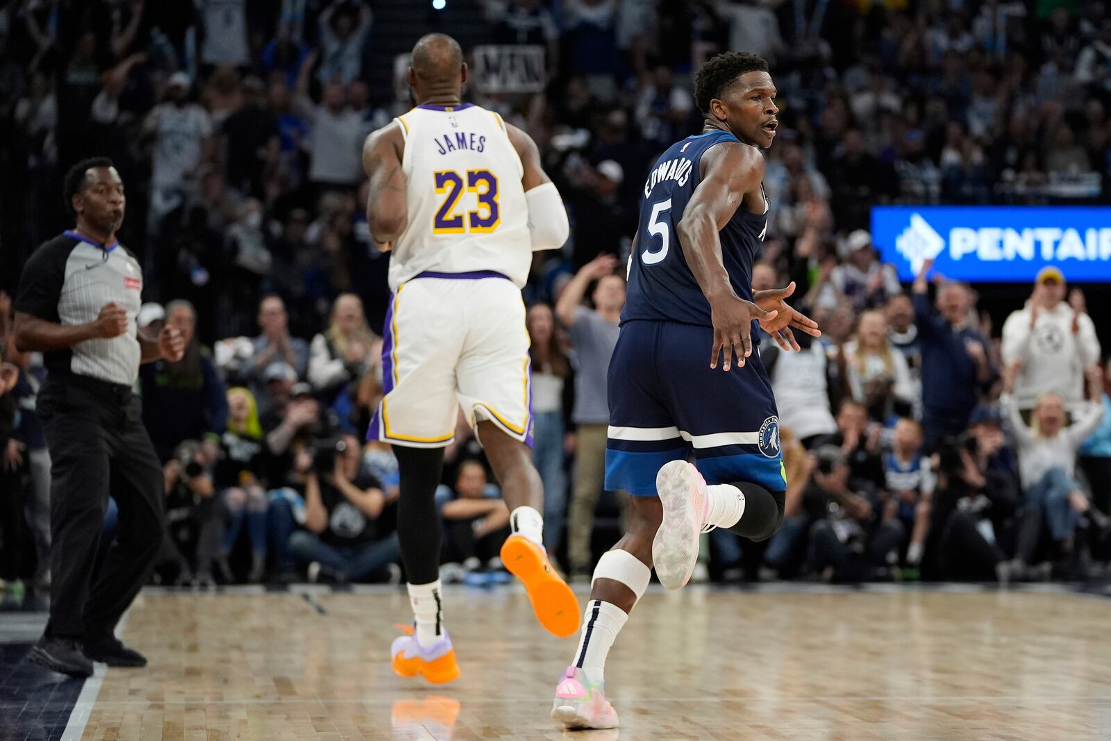 Minnesota Timberwolves guard Anthony Edwards (5) celebrates next to Los Angeles Lakers forward LeBron James (23) after making a 3-point shot during the first half of Game 4 of an NBA basketball first-round playoff series, Sunday, April 27, 2025, in Minneapolis. (AP Photo/Abbie Parr)