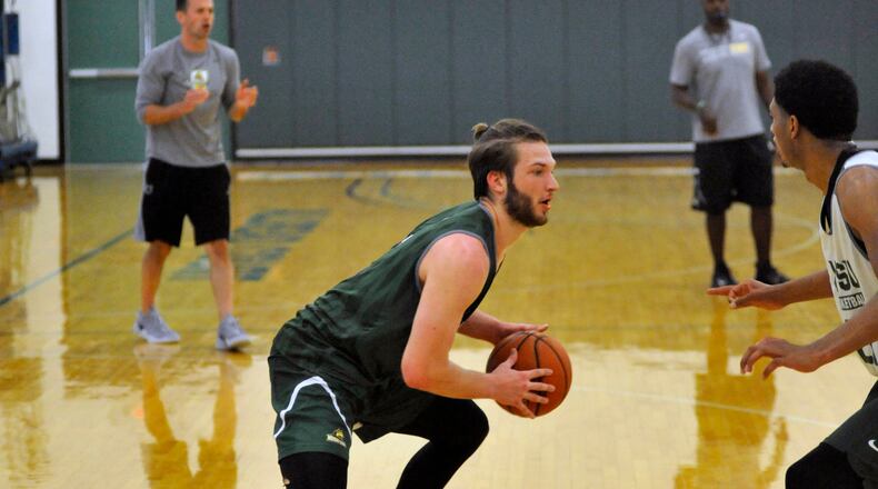 Wright State sophomore Bill Wampler looks for a driving lane against freshman James Manns during summer practice Thursday at the Stelzer Pavilion. STAFF FILE