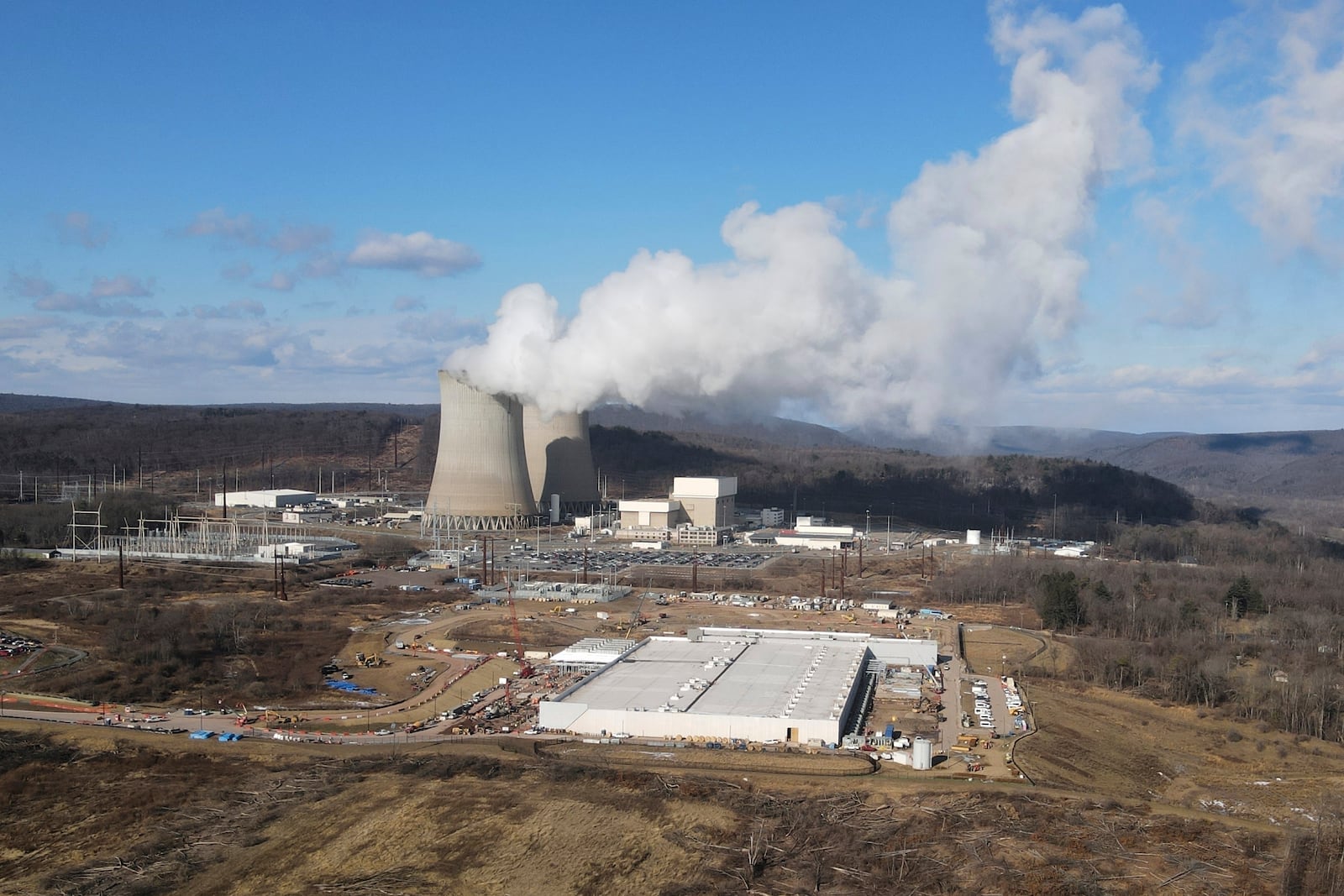A data center owned by Amazon Web Services, front right, is under construction next to the Susquehanna nuclear power plant in Berwick, Pa., on Jan. 14, 2024. (AP Photo/Ted Shaffrey)