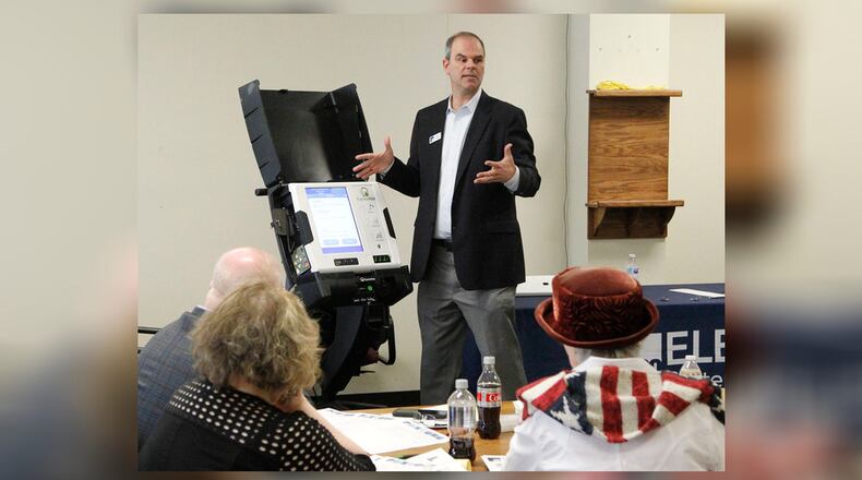 Craig Seibert, regional sales manager, from Election Systems & Software demonstrates a voting machine to the Greene County Board of Elections in Xenia. Dominion Voting Systems machines were demonstrated in a later session.    TY GREENLEES / STAFF