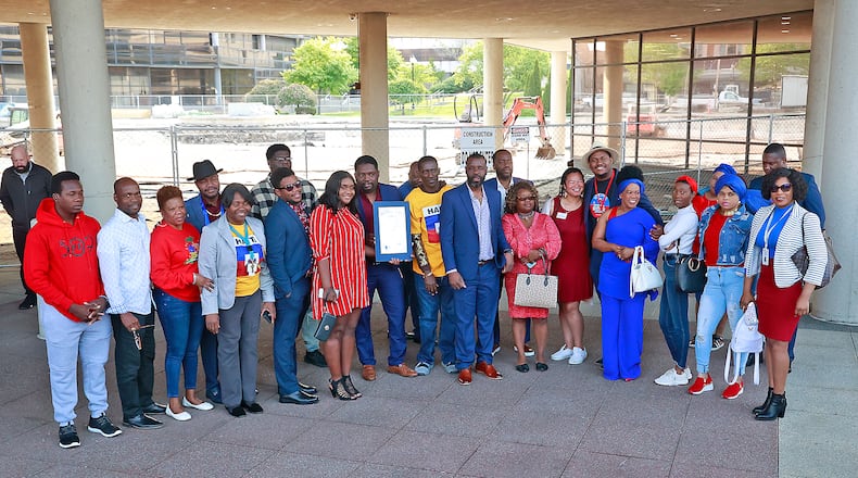 A group of Haitians pose for a picture during a ceremony Thursday, May 18, 2023 to raise the Haitian flag for the Flag Day holiday in Haiti. BILL LACKEY/STAFF