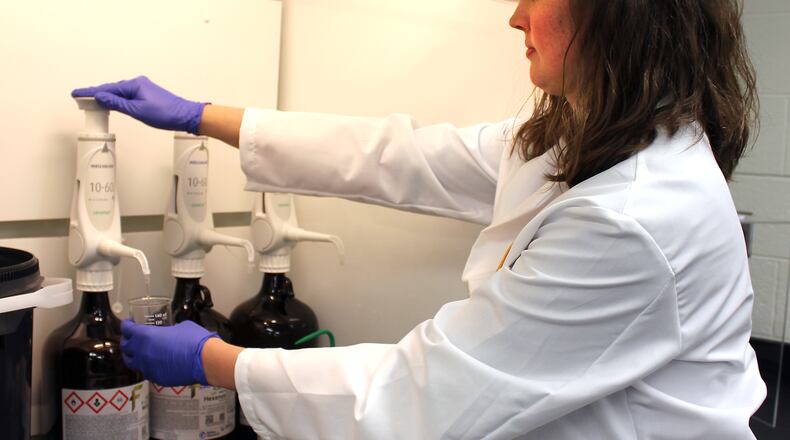 Megan Snyder, a BCI Forensic Scientist fills a beaker in the crime lab located in the Public Safety Building in Springfield. JEFF GUERINI/STAFF