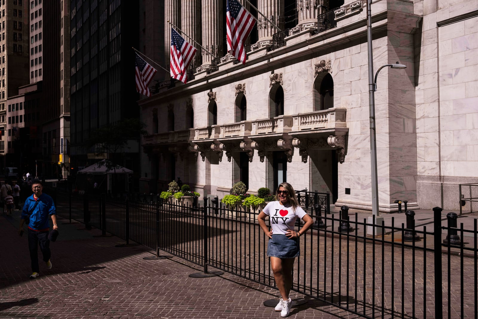 A tourist takes a picture in front of the New York Stock Exchange on Monday, June 30, 2025, in New York. (AP Photo/Yuki Iwamura)