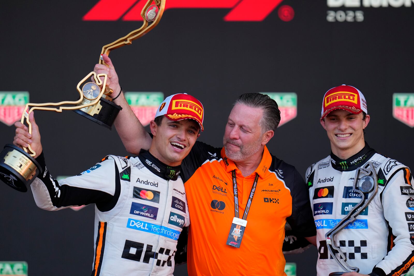 McLaren driver Lando Norris of Britain, left, celebrates on the podium with Zak Brown, McLaren chief, center, and McLaren driver Oscar Piastri of Australia after winning the Formula One Monaco Grand Prix race at the Monaco racetrack in Monaco, Sunday, May 25, 2025. (AP Photo/Manu Fernandez)
