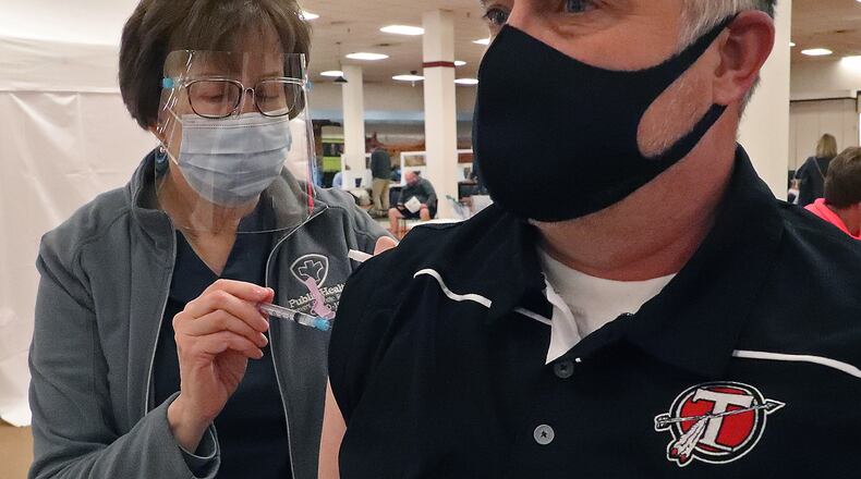 Aaron Oakes, from Tecumseh High School, gets a COVID-19 vaccine injection at the Clark County Combined Health District's distribution Center. BILL LACKEY/STAFF